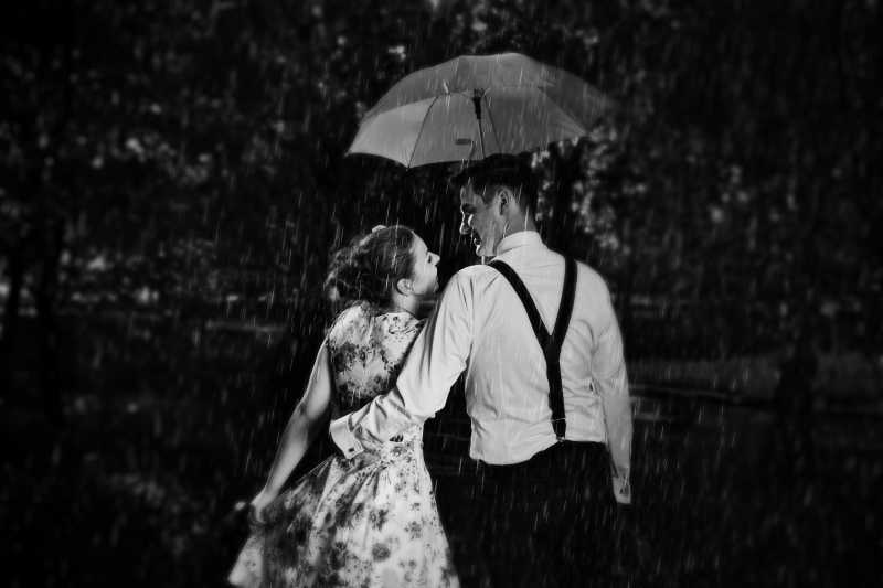 恋爱中的年轻情侣在雨中调情