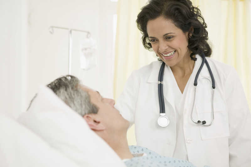 微笑的女医生看着病床上的病人
