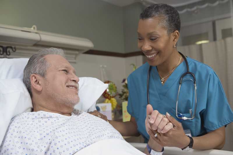 女护士微笑的看着老年病人