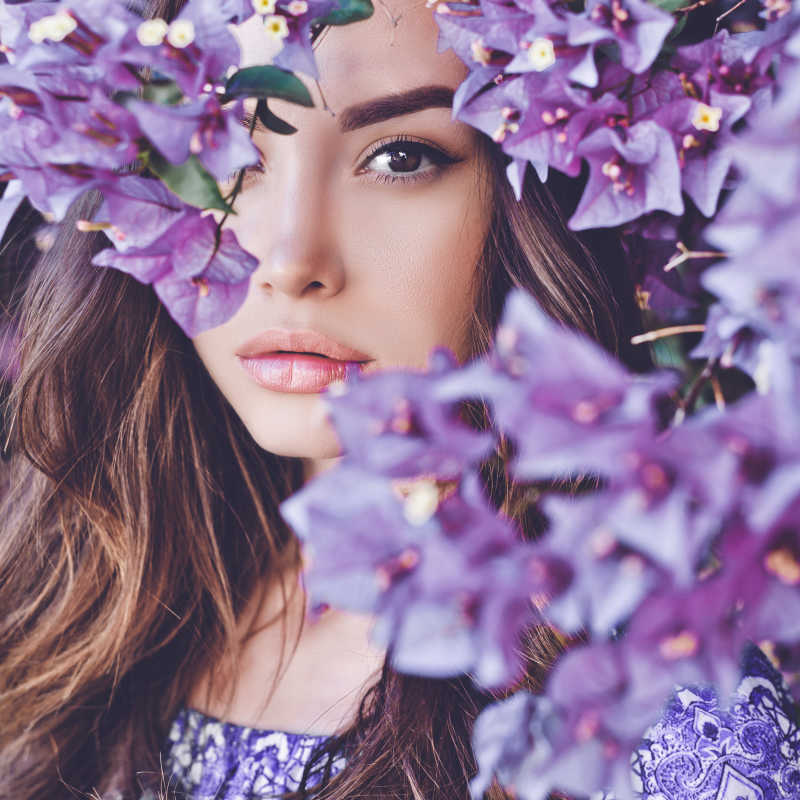 被紫色鲜花遮挡的美女