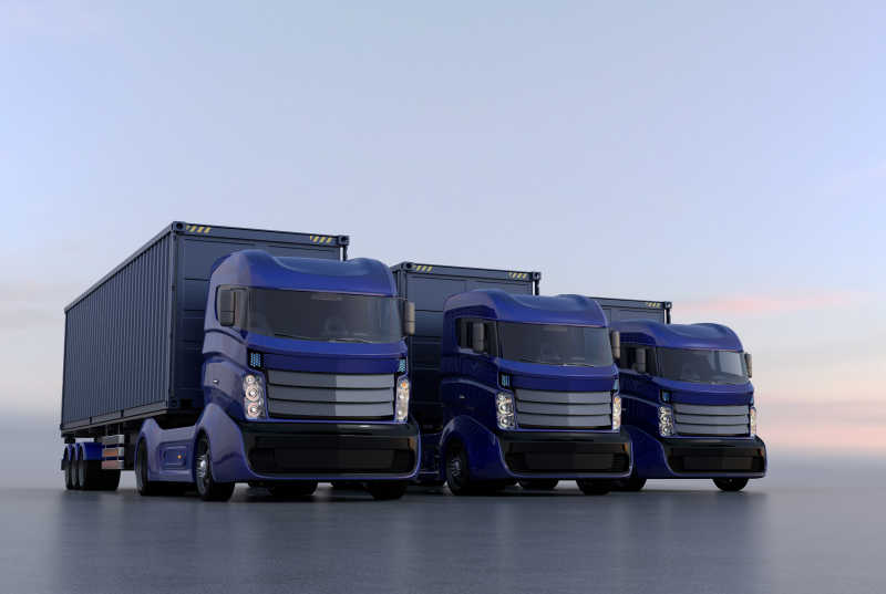 傍晚行驶的三辆蓝色的货车