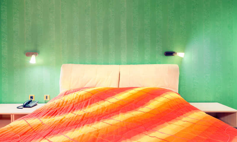 酒店客房内部绿色的墙纸和红色的窗垫