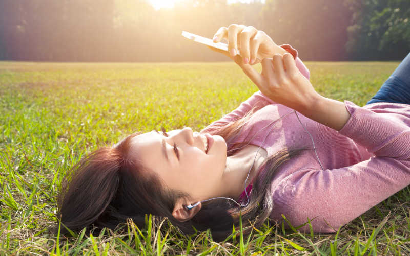 女子在草坪上看手机