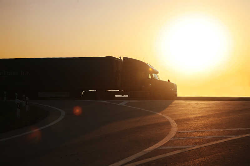 卡车在日落时行驶在公路上