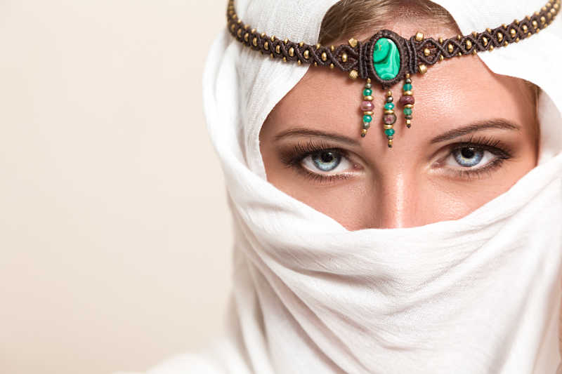 白色头巾面纱的年轻漂亮阿拉伯女人带着漂亮的头饰