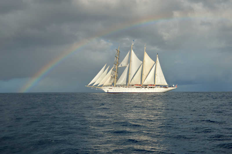 大海上彩虹背景下的帆船