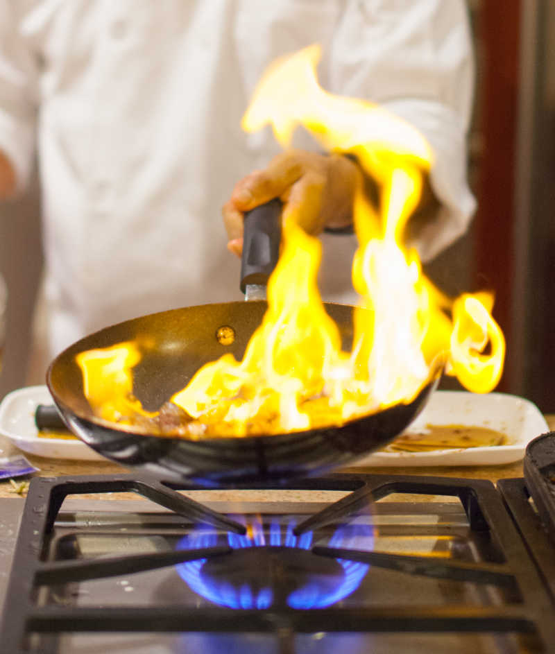 厨师用平底锅烹饪火焰