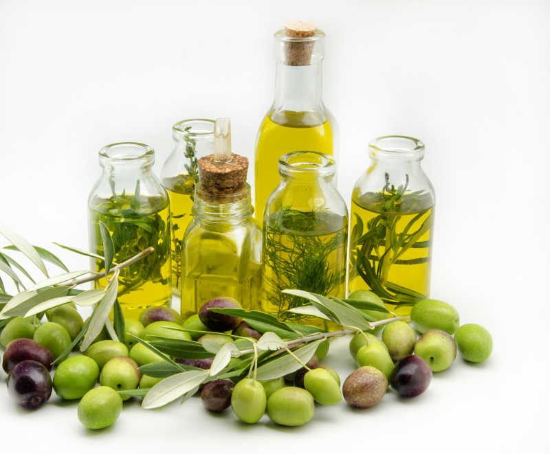 白色背景下的瓶装新鲜橄榄油和橄榄果
