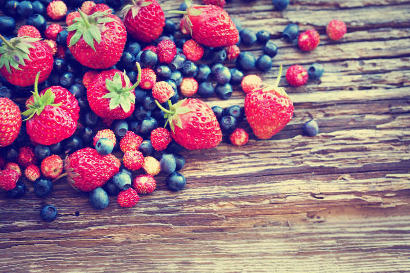 木制背景的草莓和蓝莓