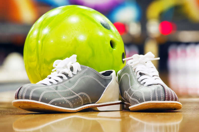 保龄球馆里干净的木地板上的保龄球和运动鞋