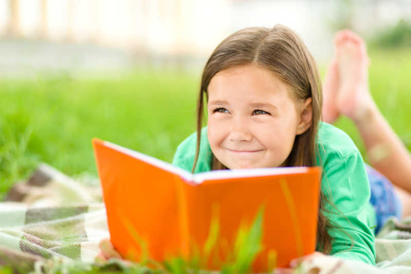 草地上看书的小女孩
