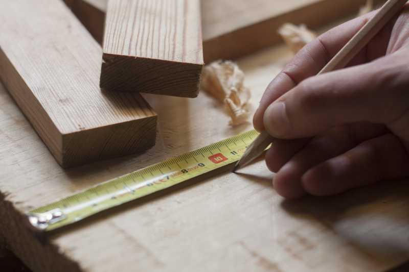 正在测量木材的木匠