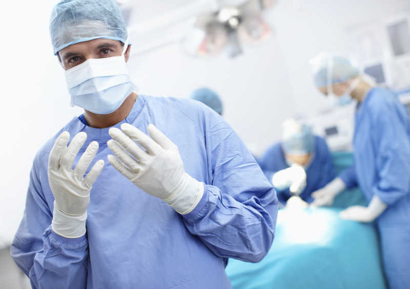 手术室戴着手术手套的外科医生