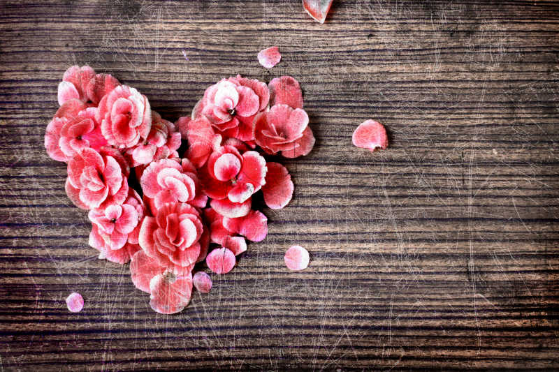 木桌上的心形玫瑰花瓣