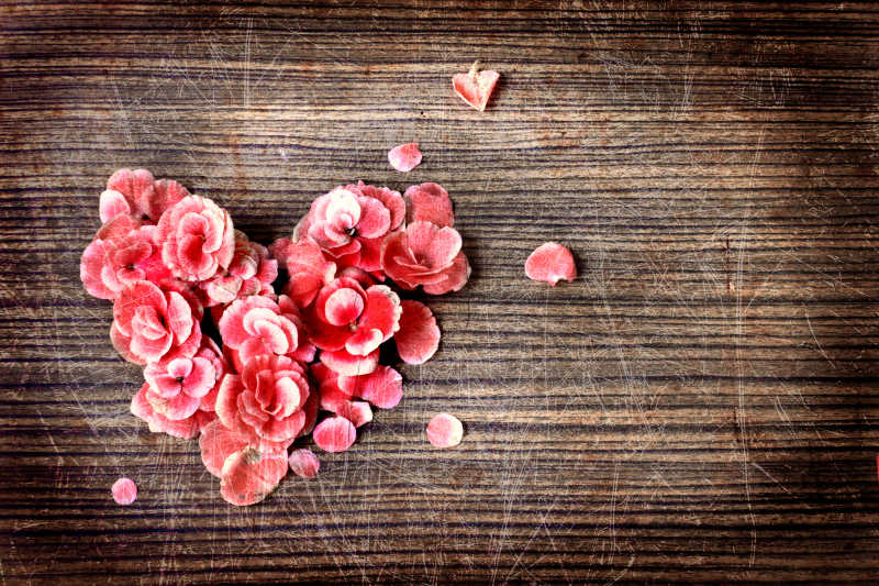 木制桌上的心形玫瑰花瓣