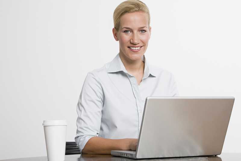白色背景上用笔记本电脑打字的女商人