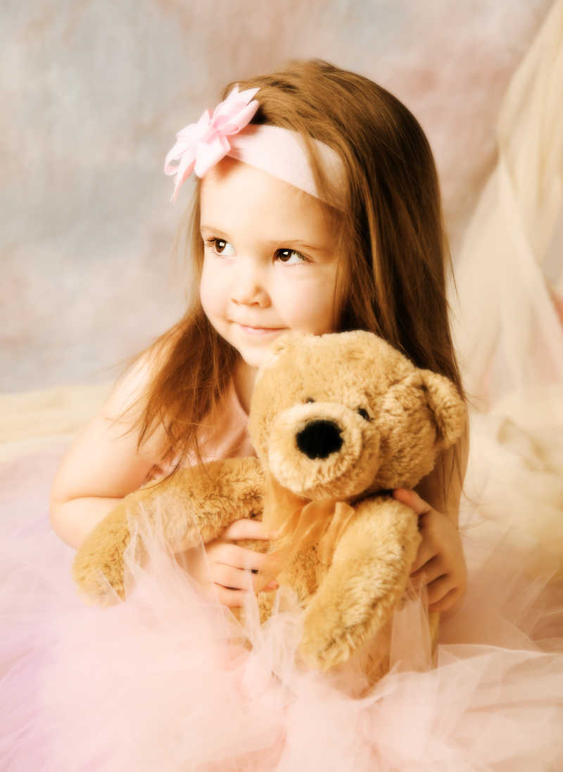 抱着小熊毛绒玩具的小女孩
