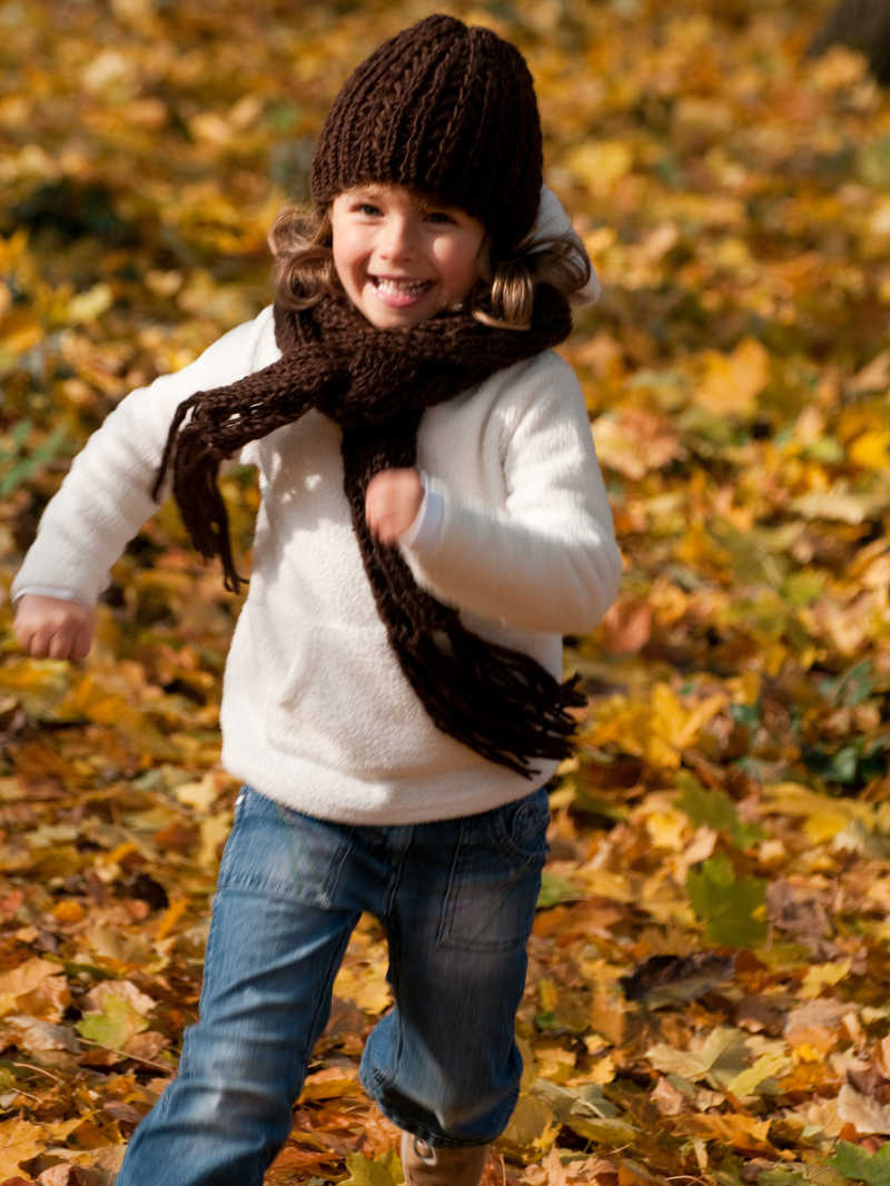 在秋天的户外跑步的快乐女孩