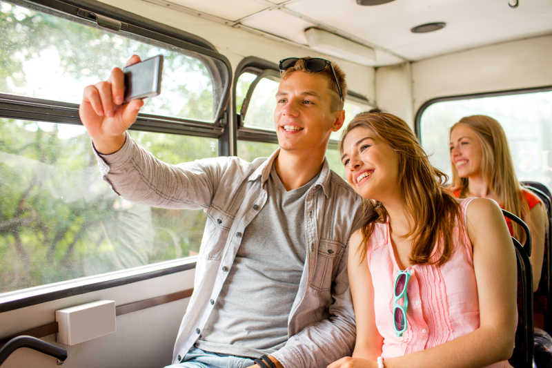 夫妇乘坐旅游巴士用手机自拍
