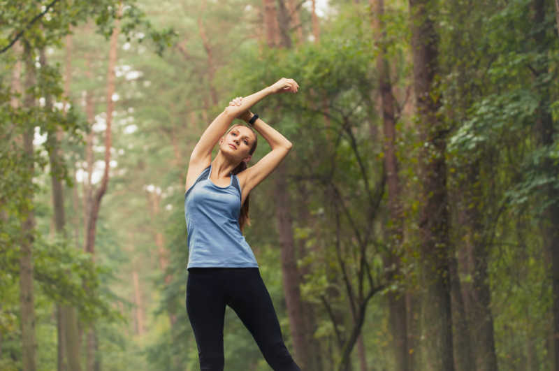 健康生活方式健身运动女性在清晨跑步前在森林地区跑步