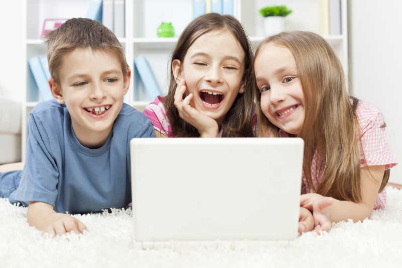 三个孩子玩笔记本电脑