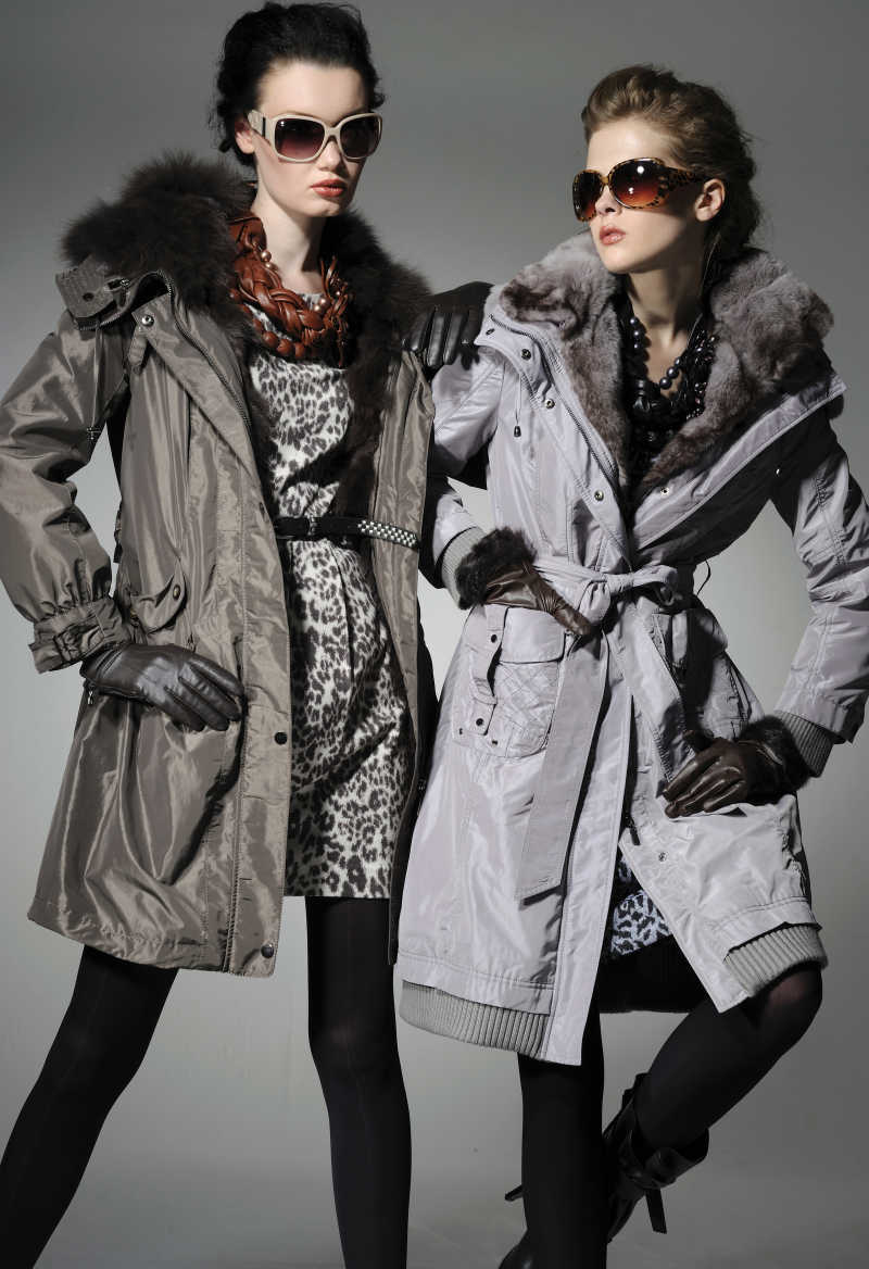 灰色背景下戴墨镜的两位秋冬服装模特