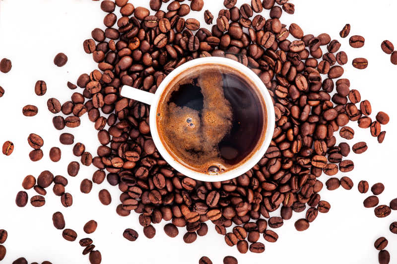 白色背景下的咖啡豆与咖啡杯