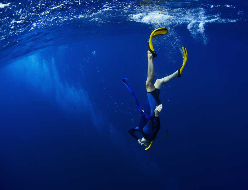 蓝色海洋中自由潜水的潜水员