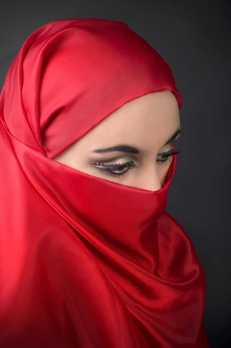 一个年轻的女孩戴着红色面纱