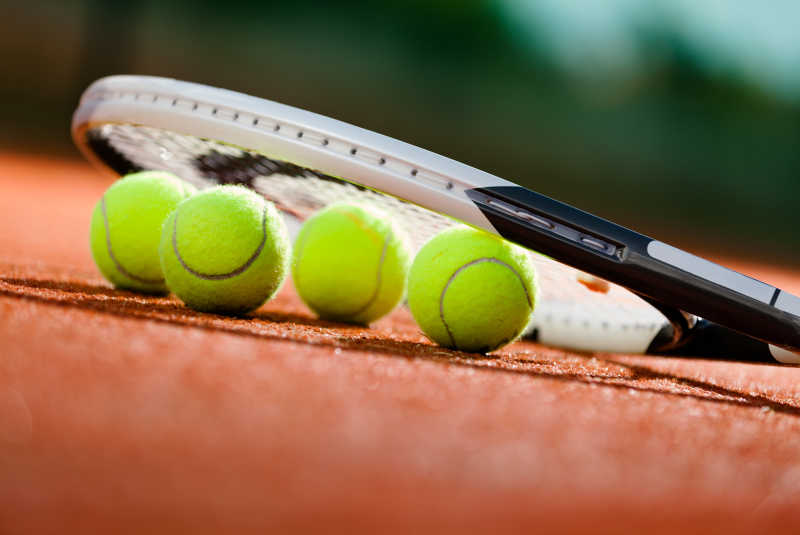 在网球场上网球拍和球的特写镜头