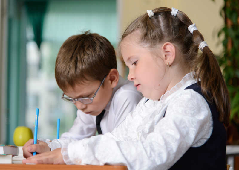 两个可爱的小学生在课堂上做作业