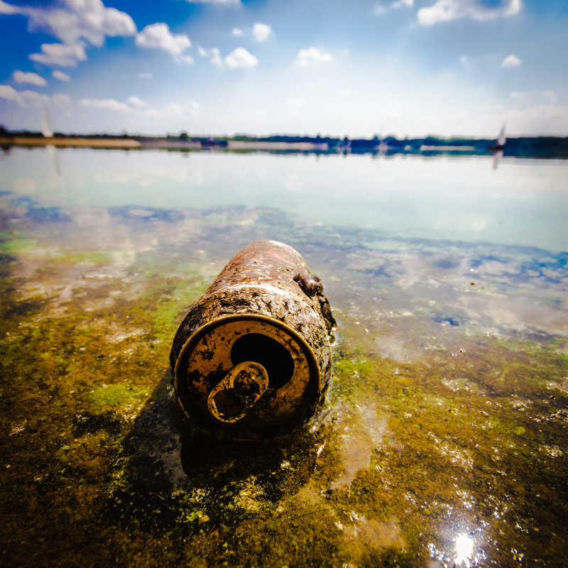 污水边被废弃的饮料瓶
