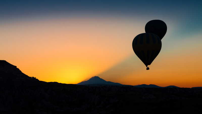 日落山峰背景下的热气球