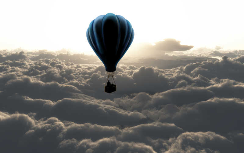 白色背景下的云朵上的蓝色热气球