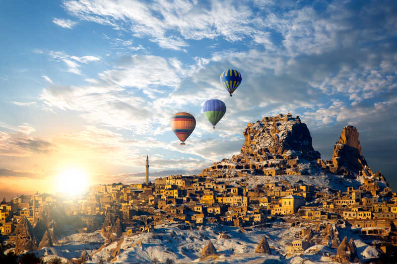 蓝天白云阳光背景下卡帕多西亚城市上空的热气球