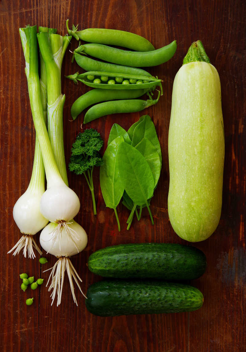 新鲜的绿色蔬菜和深色背景的香草植物的概念