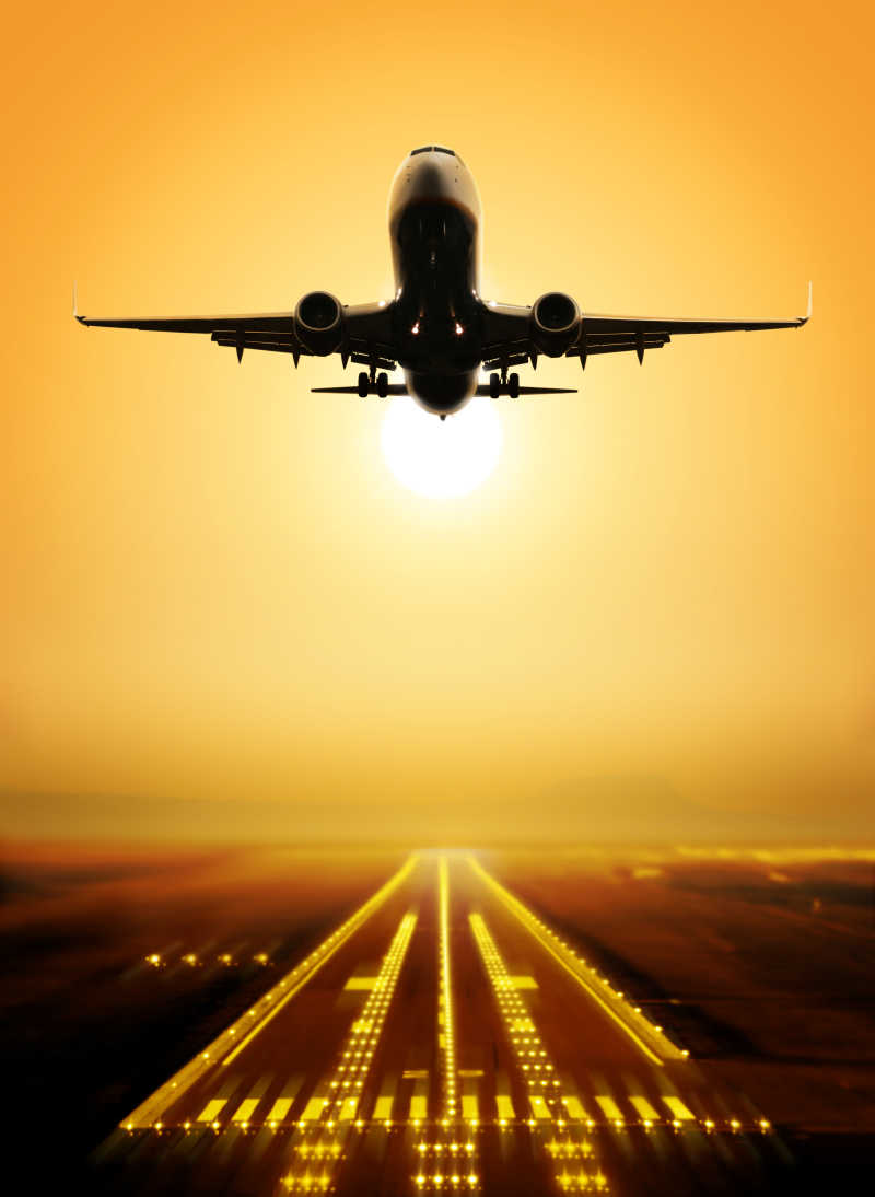 客机在日落时从机场上空起飞跑道起飞