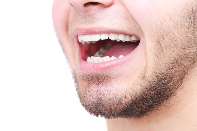 白色背景下一个白人露着洁白的牙齿在微笑