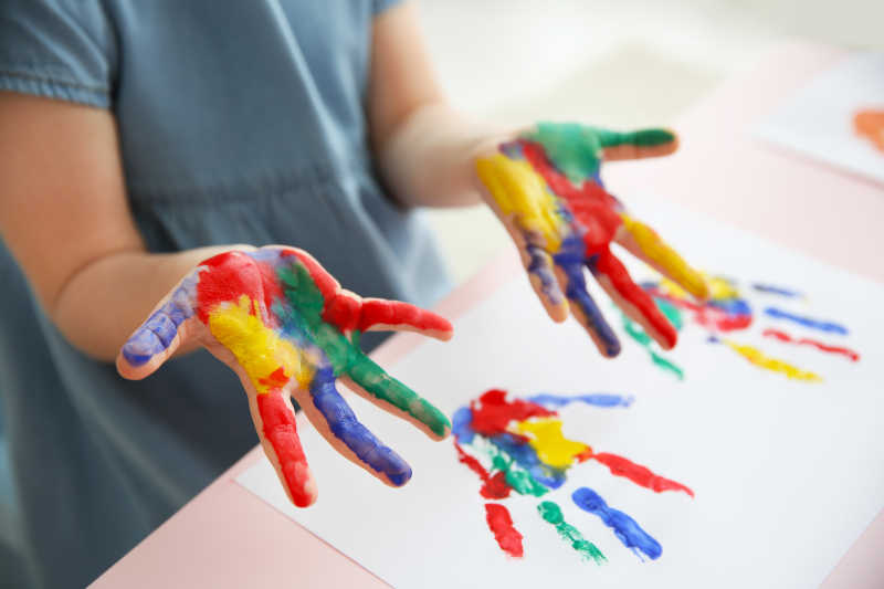 纸上的儿童手印和画着颜料的手