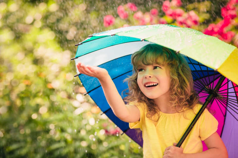撑着伞的快乐小女孩