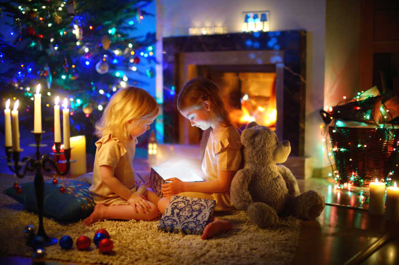 在客厅里两个小孩打开一个神奇的圣诞礼物