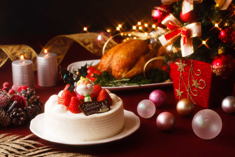 黑色圣诞节装饰物背景下的圣诞节蛋糕和美食