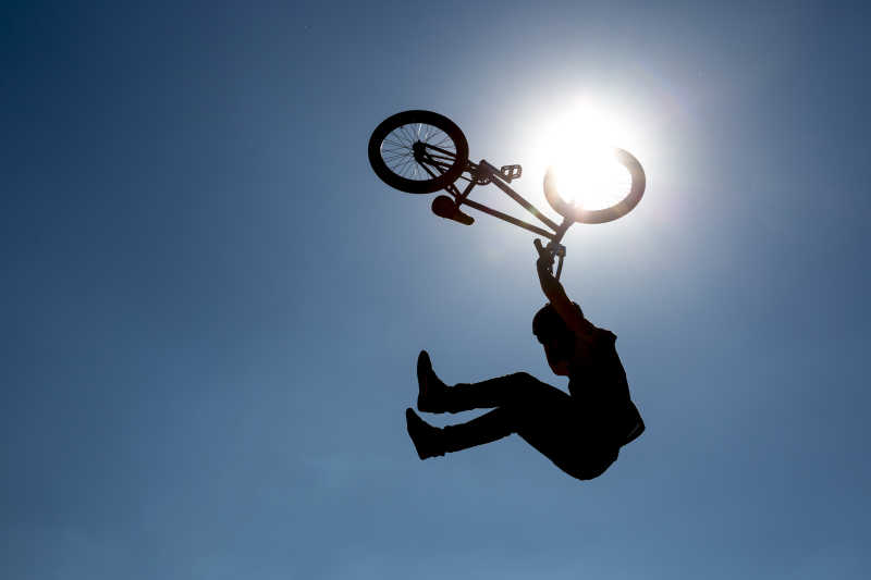 一个骑摩托车的人跳跃着在蓝色天空下
