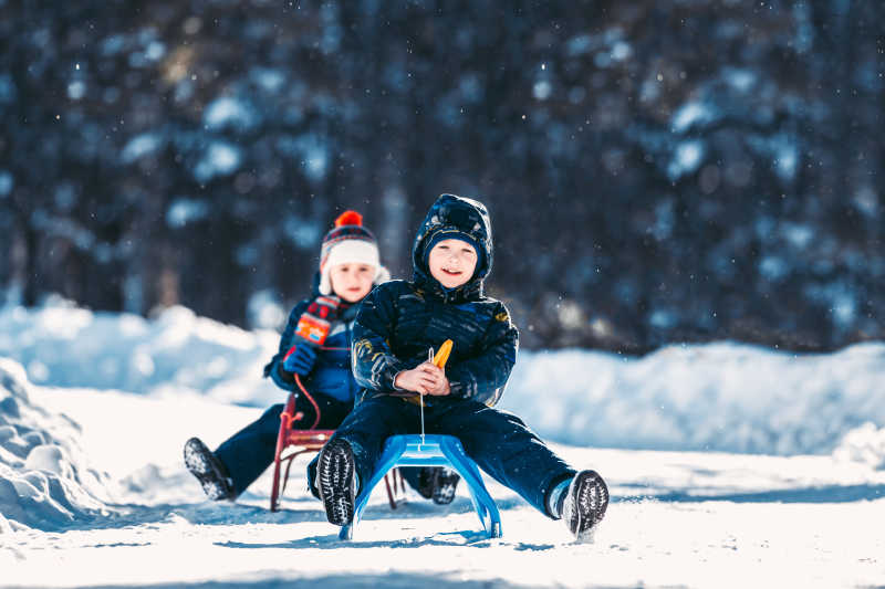 两个孩子正在玩雪橇
