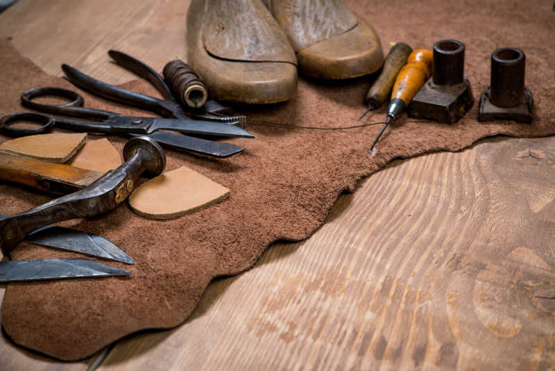 木制背景的皮革工艺工具