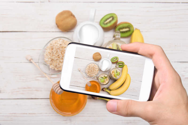 手拍照香蕉猕猴桃和燕麦与智能手机