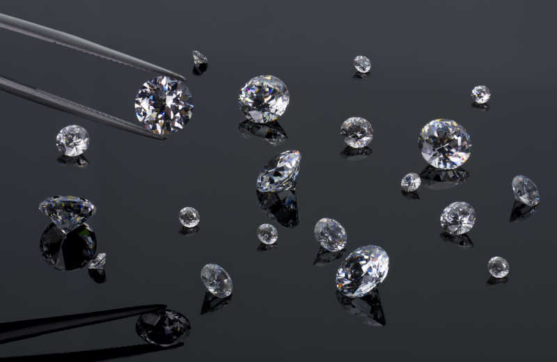 钻石在镊子上的背景与其他钻石