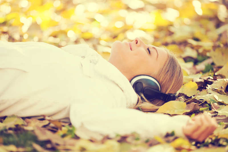 躺在地上听音乐放松的年轻美女