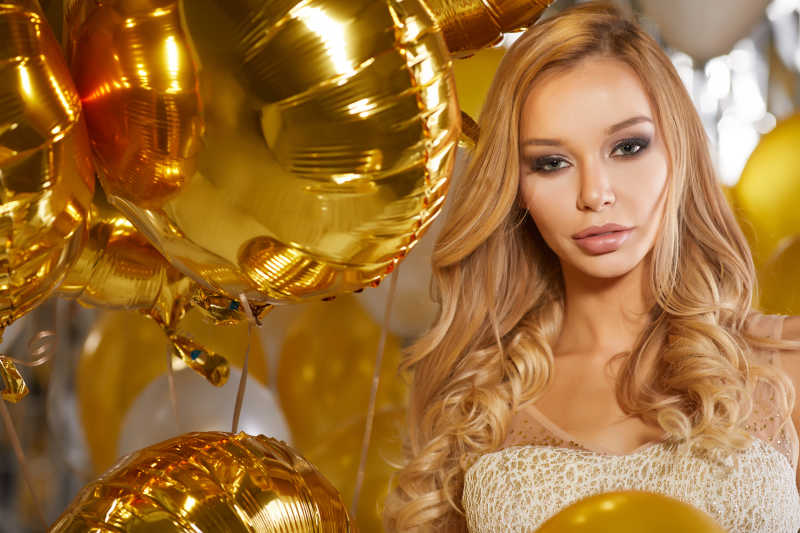金色轻气球与丝带之间的金发女郎画像