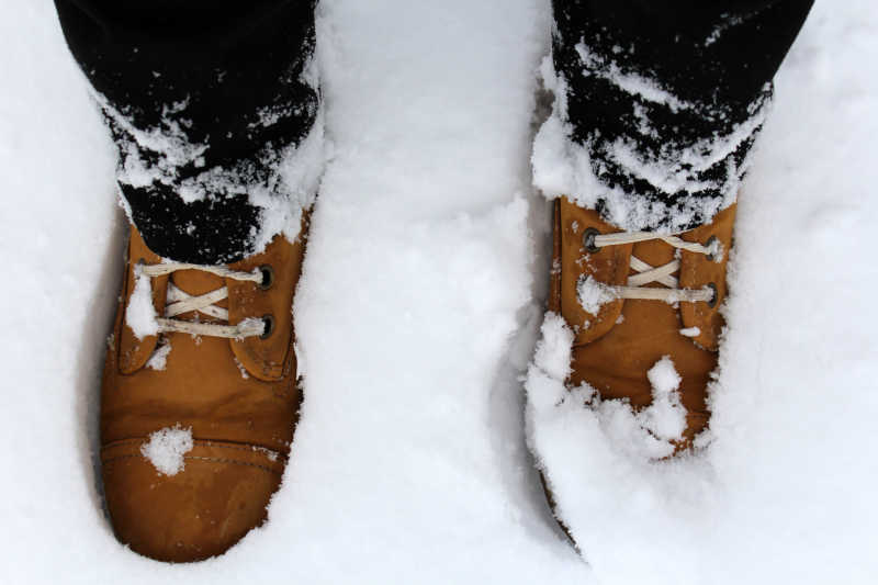 雪地里穿着棕色靴子的腿